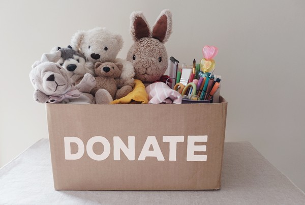 a box full of used toys, cloths, books and stationery for donation